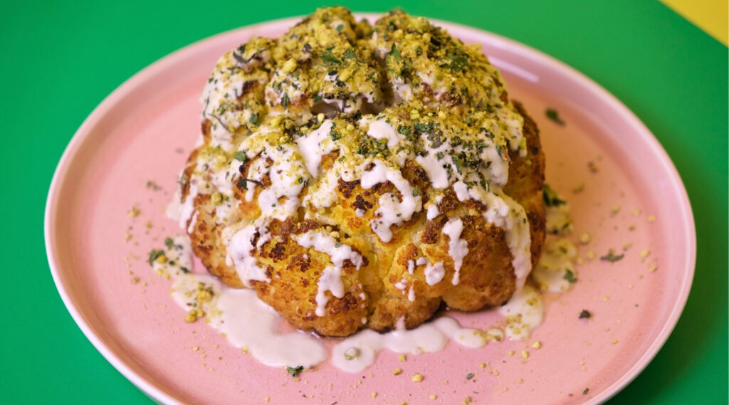 Roasted Cauliflower topped with Miso Tahini, Pistachios and Herbs.